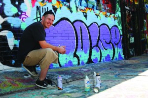 Dillion Herd (JCCC student and Graffiti artist) shows his finished project. Herd domonstrated the process on Saturday, Sept. 26, 2015 at “Legal Alley” downtown Kansas City.
