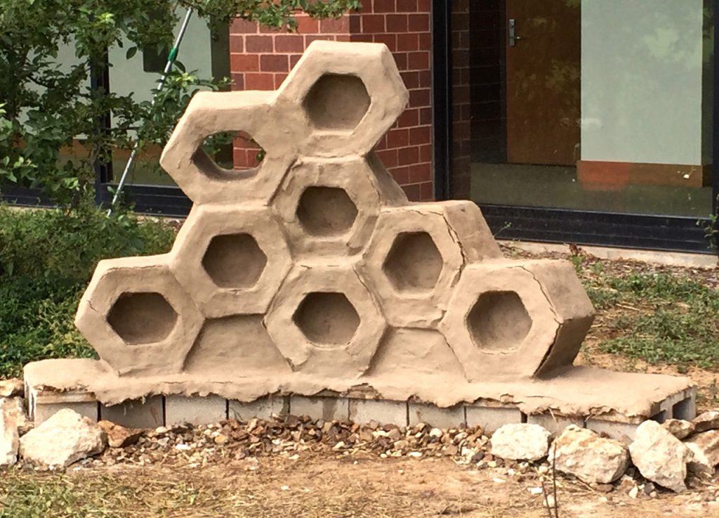 Laura Averill's cob-made (clay, straw and sand) sculpture "Economy", part of the JCCC student Sculpture Sustainability Project, addresses the concerns of GMO's on honeybees and their importance of bees in the food chain. 